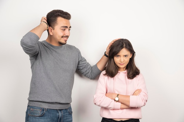 Hombre disculpándose con su novia loca en blanco.