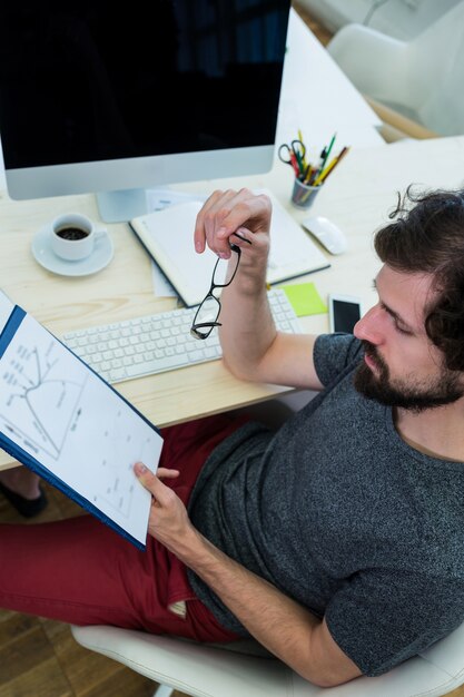Hombre diseñador gráfico mirando a un documento