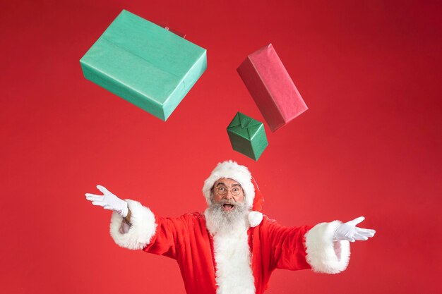 Hombre disfrazado de santa lanzando regalos en el aire