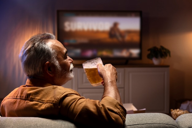 Hombre disfrutando de una cerveza mientras está solo en casa