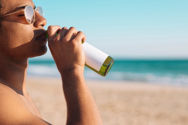 Hombre disfrutando de la cerveza a la orilla del mar