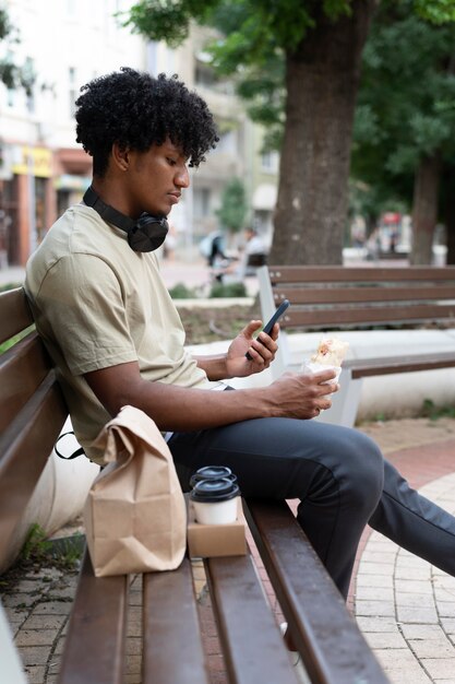 Hombre disfrutando de comida para llevar al aire libre