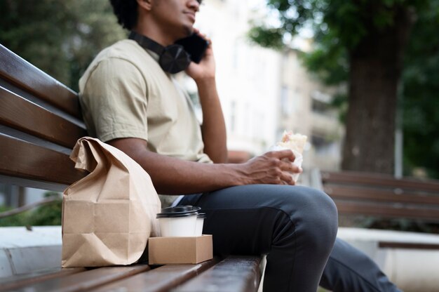 Hombre disfrutando de comida para llevar al aire libre