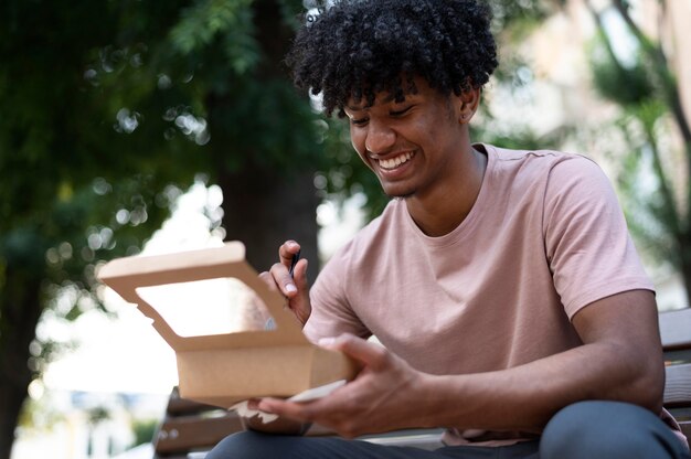 Hombre disfrutando de comida para llevar al aire libre