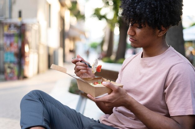 Hombre disfrutando de comida para llevar al aire libre