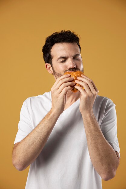 Hombre disfrutando comiendo una hamburguesa