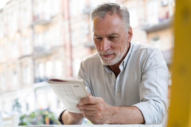 Hombre disfrutando de un juego de sudoku en papel por sí mismo