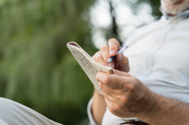 Hombre disfrutando de un juego de sudoku en papel por sí mismo