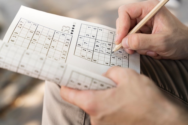 Hombre disfrutando de un juego de sudoku en papel