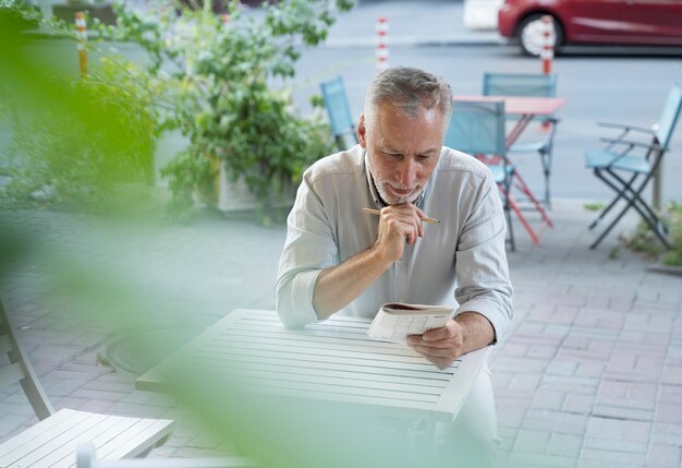 Hombre disfrutando de un juego de sudoku en papel