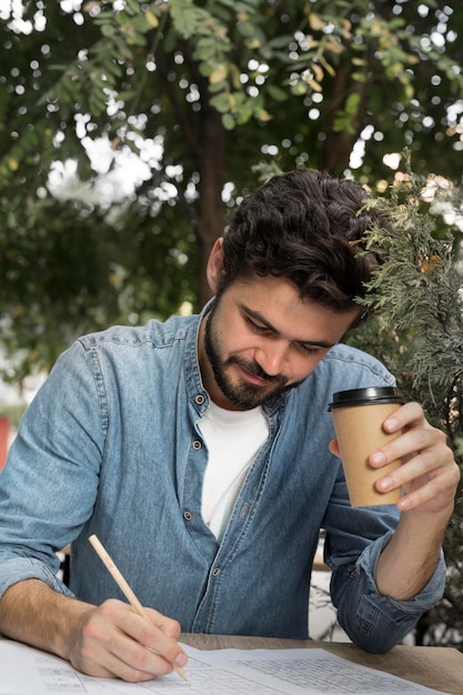 Foto gratuita hombre disfrutando de un juego de sudoku en papel