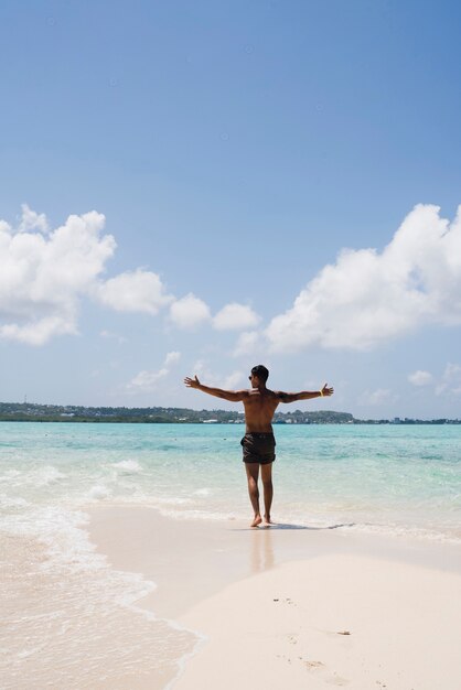 Hombre disfrutando de la luz del sol en la playa