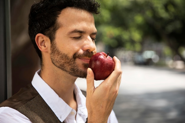 Hombre disfrutando de una manzana al aire libre