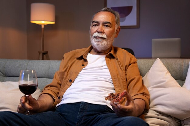 Hombre disfrutando de un poco de vino mientras está solo en casa