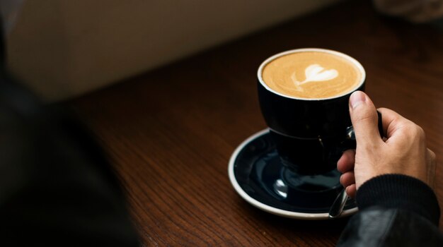 Hombre disfrutando de una taza de café caliente en un café