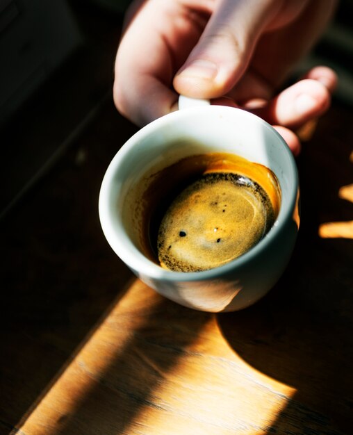 Hombre disfrutando de una taza de café caliente en un café