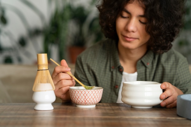 Foto gratuita hombre disfrutando de una taza de té matcha