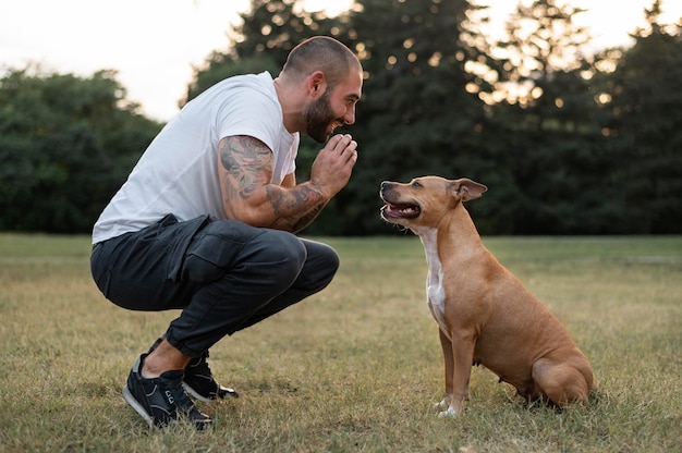Foto gratuita hombre disfrutando de un tiempo de calidad con su perro