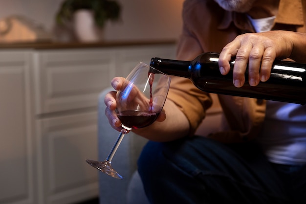 Hombre disfrutando del vino mientras está solo en casa
