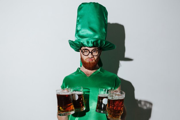 Hombre disgustado en traje de patriotas con muchas tazas