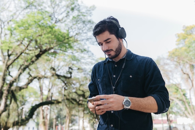 Hombre con dispositivos relajante en el parque