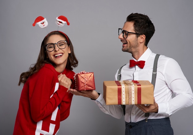 Hombre divertido dando el regalo de Navidad