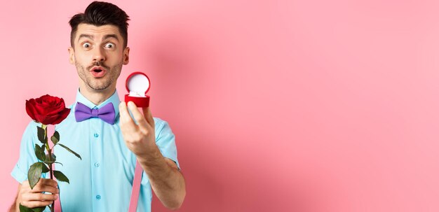 Foto gratuita hombre divertido del día de san valentín con bigote y pajarita haciendo propuesta mostrando anillo de compromiso y propo