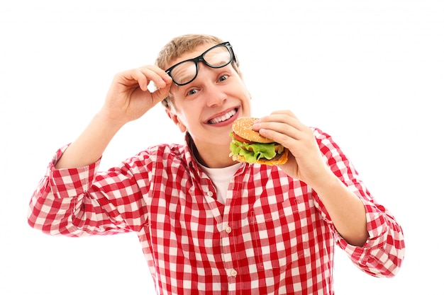 Hombre divertido en vasos comiendo hamburguesas aislado en un blanco