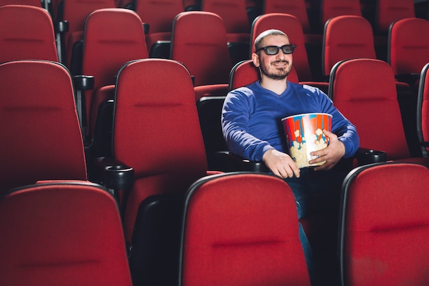 Hombre divertido viendo la película en el cine