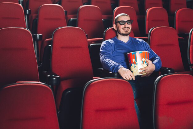 Hombre divertido viendo la película en el cine