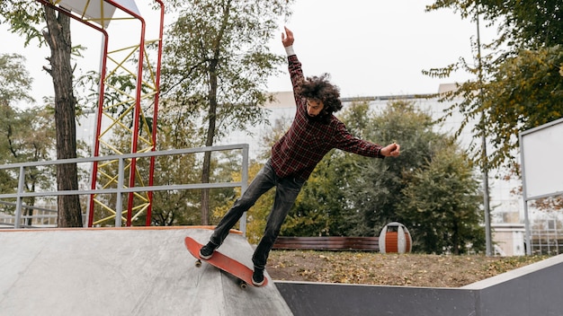 Foto gratuita hombre divirtiéndose con patineta afuera en el parque de la ciudad