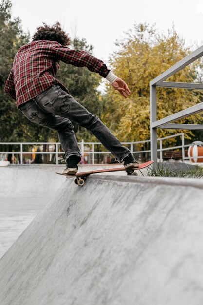 Hombre divirtiéndose con patineta en el parque