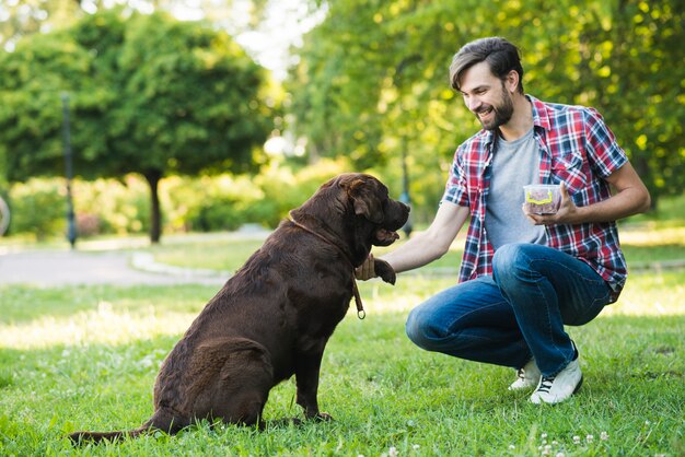 Hombre divirtiéndose con su perro en el jardín