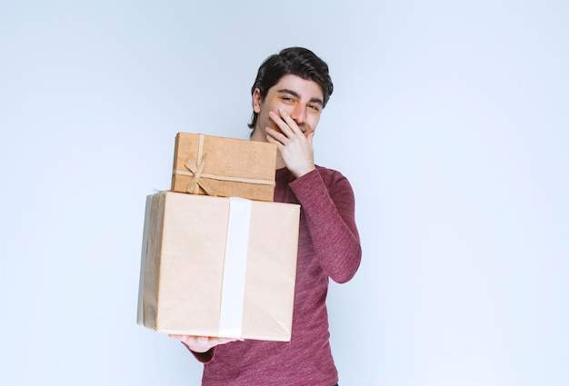 Hombre con dos cajas de regalo de cartón sonriendo.