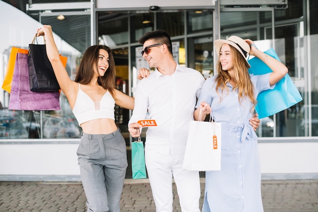 Hombre con dos mujeres sosteniendo la etiqueta de venta