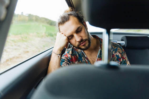 Hombre durmiendo en el asiento trasero del carro