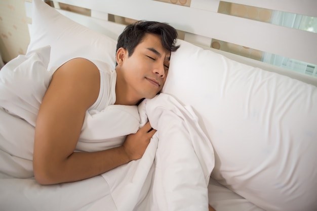 Hombre durmiendo en la cama por la mañana