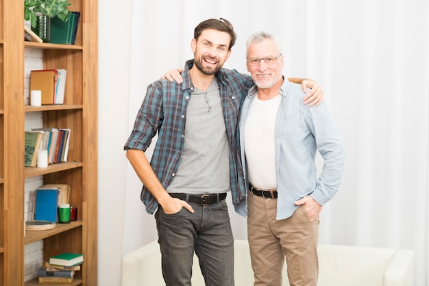 Hombre de edad abrazando con chico feliz joven