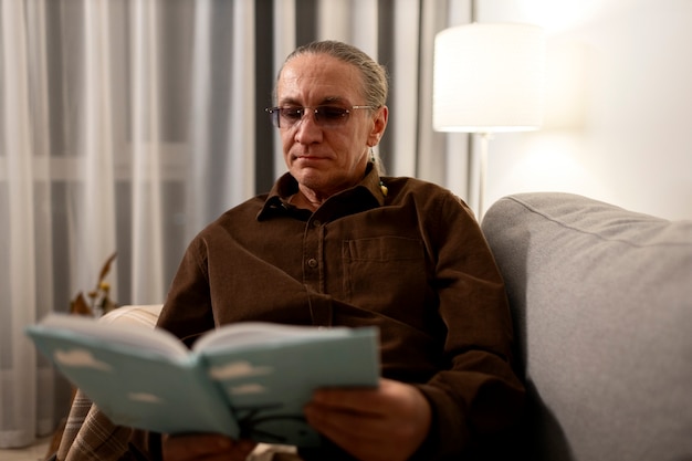 Hombre de edad mediana leyendo en casa.