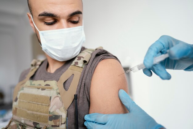 Hombre del ejército vacunándose