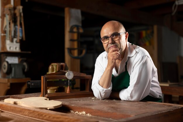 Hombre elaborando un instrumento en su taller.