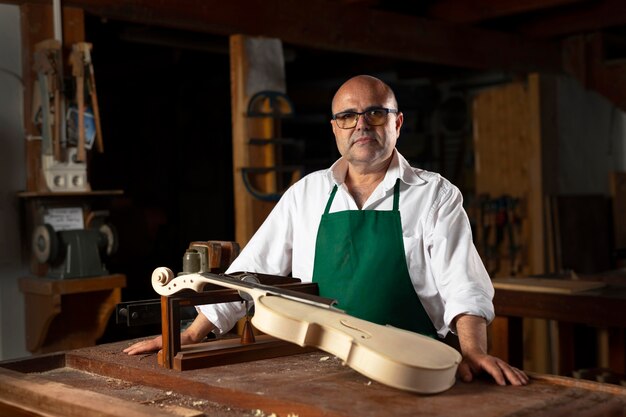 Hombre elaborando un instrumento en su taller.