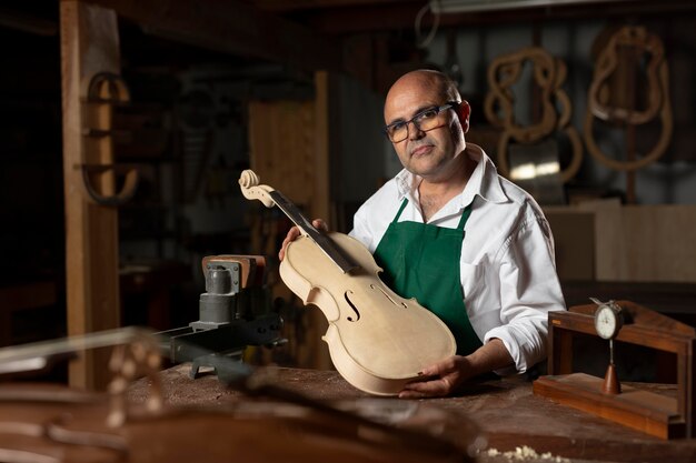 Hombre elaborando un instrumento en su taller.