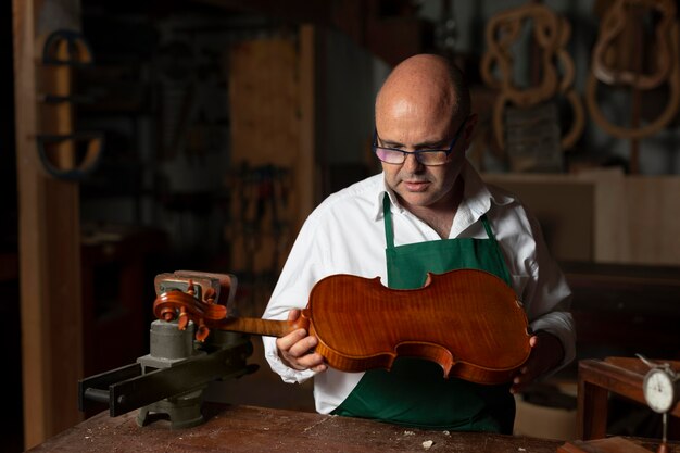 Hombre elaborando un instrumento en su taller.