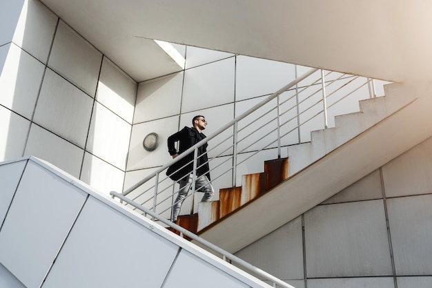 Hombre elegante con abrigo trasero subiendo al estilo Minimalizm