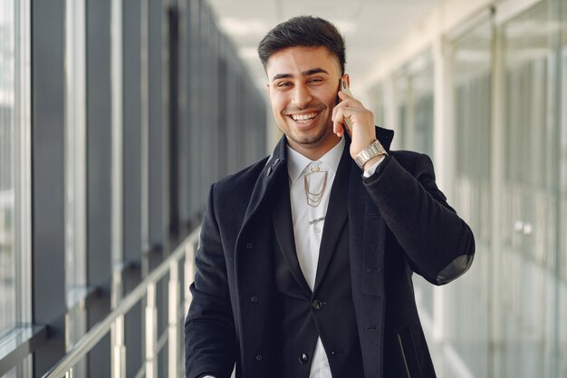 Hombre elegante en el aeropuerto con una maleta