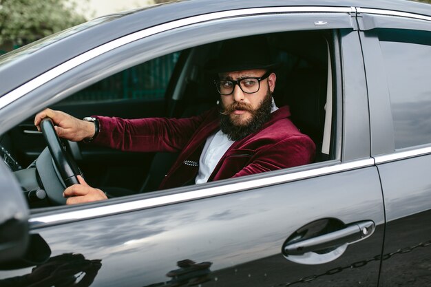 Hombre elegante conduciendo un coche de lujo