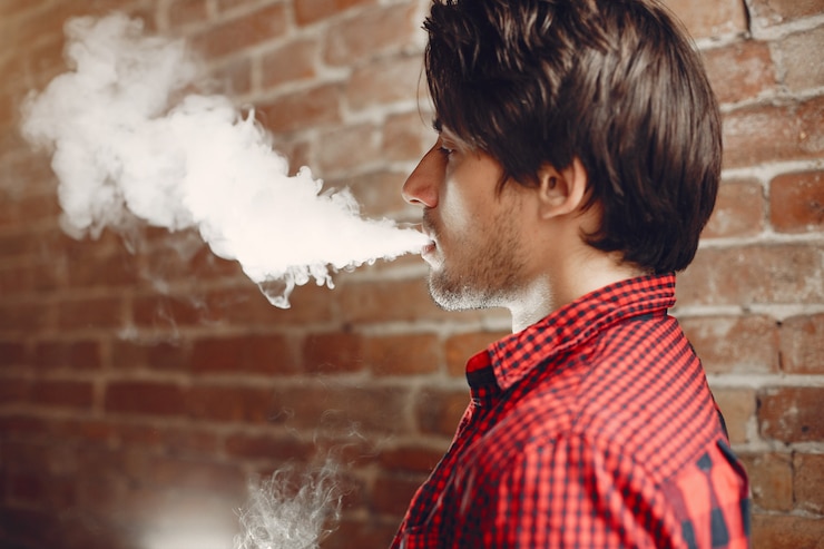 Foto gratuito hombre elegante y elegante en una ciudad con vape