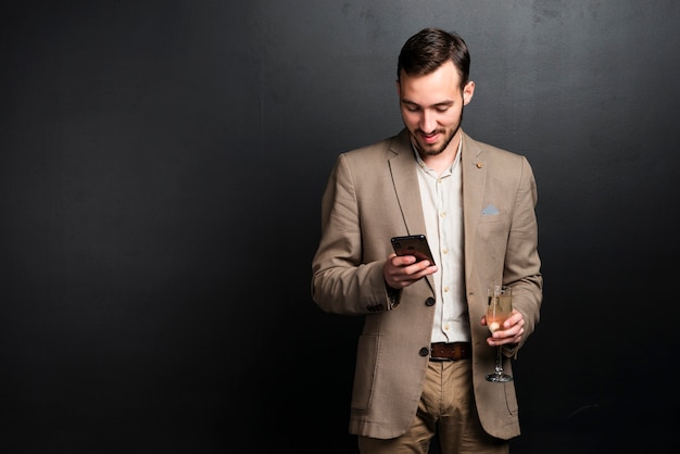 Foto gratuita hombre elegante en la fiesta mirando el teléfono