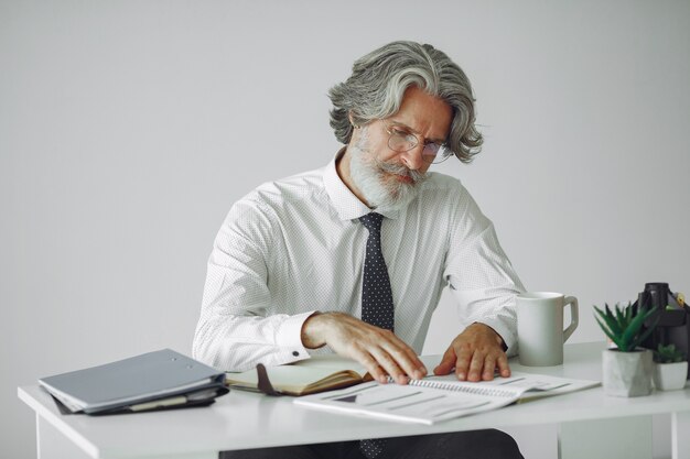 Hombre elegante en la oficina. Hombre de negocios con camisa blanca. El hombre trabaja con documentos.